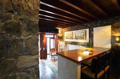 a kitchen and living room with a stone wall at Modern Luxury Canarian House in Garachico