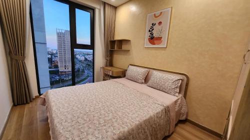 a bedroom with a bed and a large window at Căn hộ 12A11 Chung cư Sentosa Sky Park - Hải Phòng in An Khê