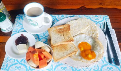 a breakfast plate with toast and eggs and a cup of coffee at Hermoso Palomino in Palomino