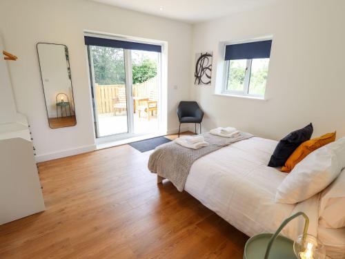 Thorpe on the HillにあるThe Lilac Owlのベッドとテーブルと椅子のある寝室