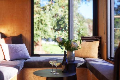 a living room with a couch and a table with wine glasses at Tiny Grace - Boutique Yarra Valley Accommodation in Healesville