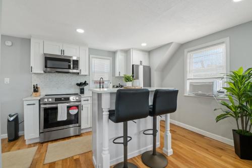 a kitchen with a stove and a counter with two chairs at LunaVista's Cozy Corner, 1B&1Bth in Hempstead