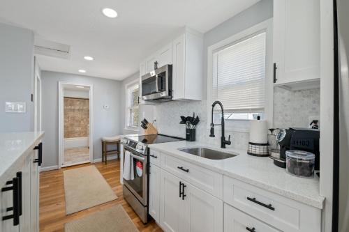 a white kitchen with a sink and a stove at LunaVista's Cozy Corner, 1B&1Bth in Hempstead
