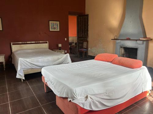 two beds in a room with a fireplace at Pousada Charqueada Costa do Abolengo in Pelotas