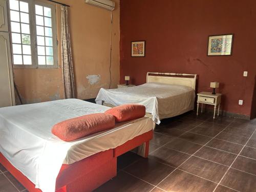 a bedroom with two beds and a window at Pousada Charqueada Costa do Abolengo in Pelotas