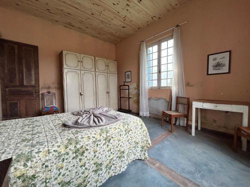 an old bedroom with a bed and a window at Pousada Charqueada Costa do Abolengo in Pelotas