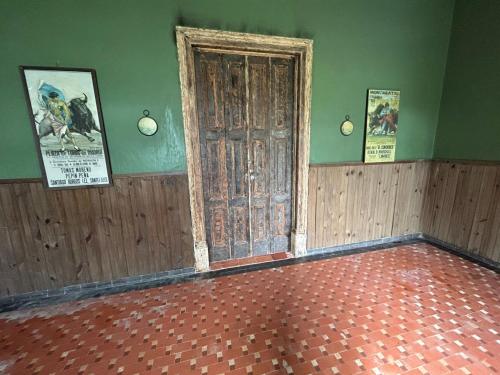 an empty room with an old door and posters on the walls at Pousada Charqueada Costa do Abolengo in Pelotas