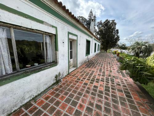 a brick sidewalk next to a building with a window at Pousada Charqueada Costa do Abolengo in Pelotas