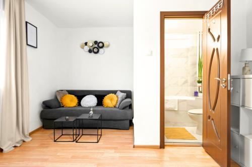 a living room with a couch and a bathroom at Stepup Apartment, Downtown Bucharest, City Center, Garden View in Bucharest