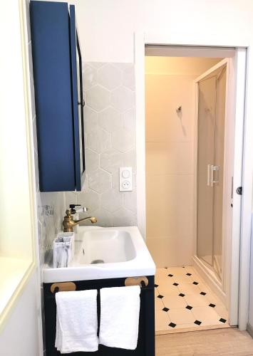 a bathroom with a white sink and a blue cabinet at La grange des Bruyères, maison rénovée, 5 chambres in Biscarrosse