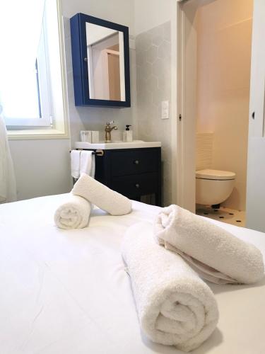 a white bedroom with a sink and towels on a bed at La grange des Bruyères, maison rénovée, 5 chambres in Biscarrosse