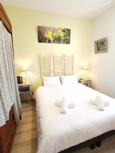 a bedroom with a large white bed with two pillows at La grange des Bruyères, maison rénovée, 5 chambres in Biscarrosse