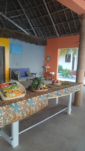 a kitchen with a counter with fruits and vegetables on it at Beach Front Bungalow in Jambiani
