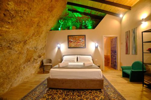 a bedroom with a bed in a stone wall at Villa Cavetta in Agrigento