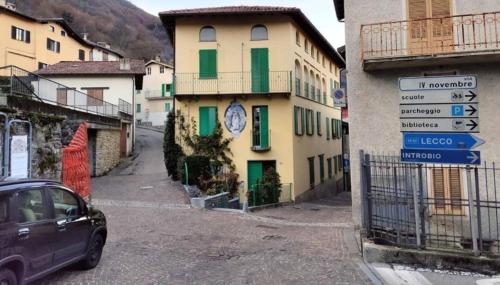 a car parked in front of a building with green windows at Chalet di Pasturo in Pasturo