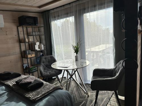 a room with a table and chairs and a window at Melnā kalna kamene in Vestiena
