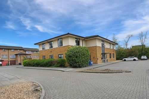 a brick building with a car parked in front of it at Milburn Retreat in Milton Keynes