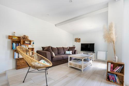 un soggiorno con un divano e un tavolo di Paisible maison à 2 pas du Bassin ad Arès