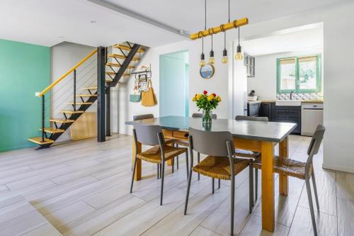 una cucina e una sala da pranzo con tavolo e sedie di Paisible maison à 2 pas du Bassin ad Arès