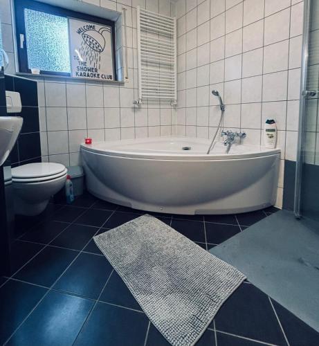 a bathroom with a tub and a toilet at TulasHomeBlue in Hamm