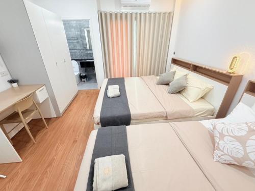 a small bedroom with two beds and a desk at CORNER STAY 210 Hatyai in Sathani Khlong Rian