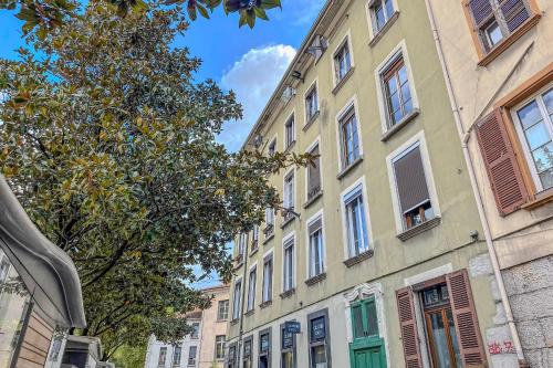 a building with green doors and windows on a street at #ID Le Notre Dame in Grenoble
