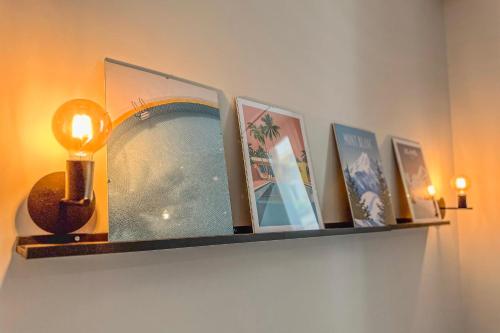 a shelf with pictures and a light on a wall at #ID Le Notre Dame in Grenoble