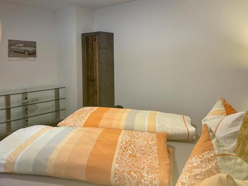a bedroom with two beds with orange and white sheets at Mompels in Rübeland