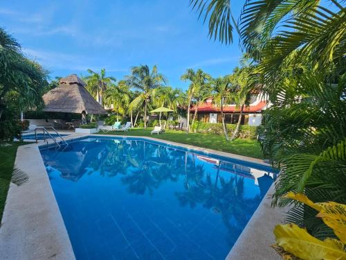 a swimming pool in front of a resort with palm trees at King's Place Cancun Hotel Zone in Cancún
