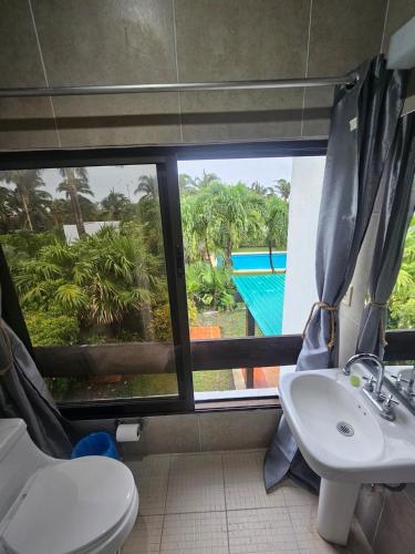 a bathroom with a toilet and a sink and a window at King's Place Cancun Hotel Zone in Cancún