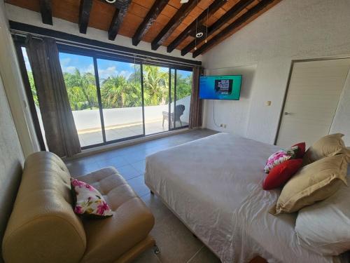 a bedroom with a bed and a couch and a large window at King's Place Cancun Hotel Zone in Cancún
