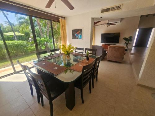 a dining room with a table and chairs and a television at King's Place Cancun Hotel Zone in Cancún