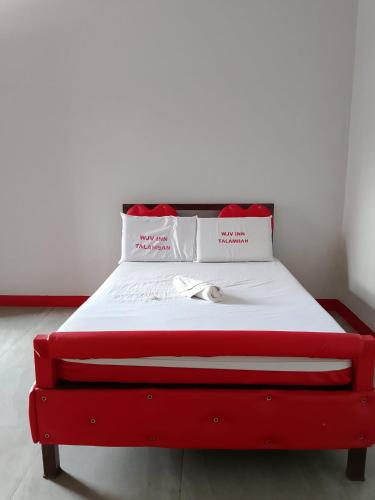 a red bed with white sheets and red pillows at Wjv Inn Talamban in Cebu City