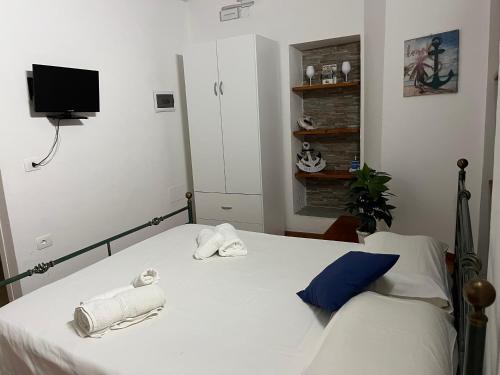 a bedroom with a bed with towels and a tv at Il Portale 2 in Tropea