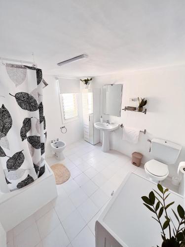 a white bathroom with a toilet and a sink at Lo Corner House in Móra d'Ebre