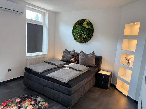 ein Schlafzimmer mit einem Bett mit einem Kranz an der Wand in der Unterkunft City Apartment 1 in Bad Nenndorf