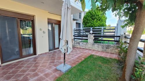 an umbrella on the patio of a house at SiviriLovelyApartment in Siviri
