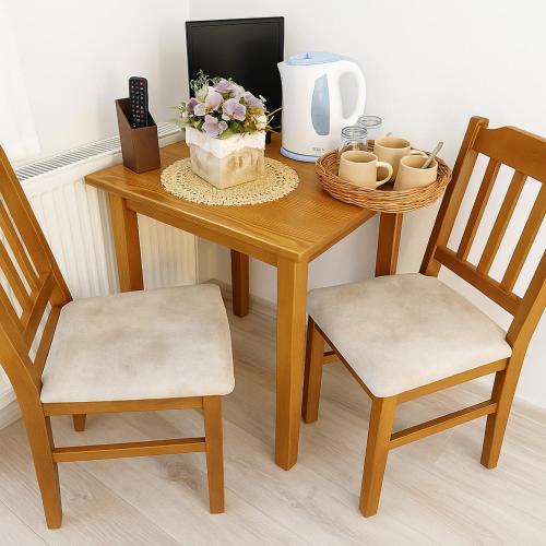 a table with two chairs and a vase with flowers on it at Penzión Erika in Dedinky