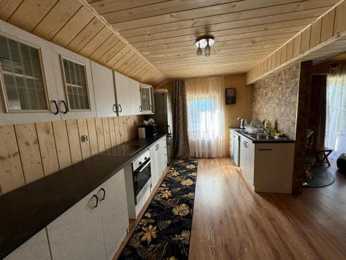 a large kitchen with wooden floors and a wooden ceiling at Apartment u Heleny in Biały Dunajec