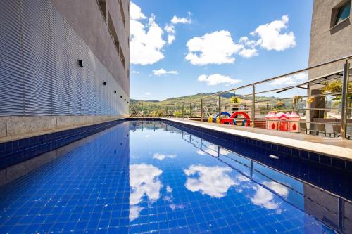 a swimming pool with a reflection of the sky in the water at IT Itabira Hotel in Itabira