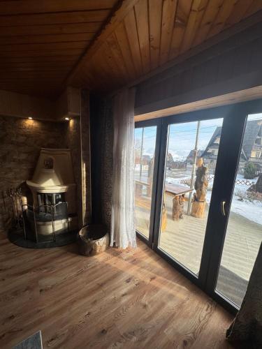 a living room with a fireplace and a large window at Apartment u Heleny in Biały Dunajec