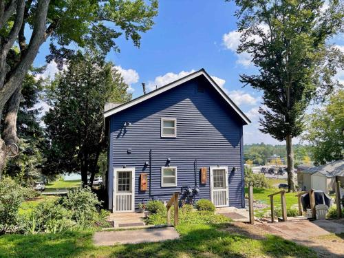 a blue house in a yard with trees at Torch Lake Vista With Lake access in Rapid City
