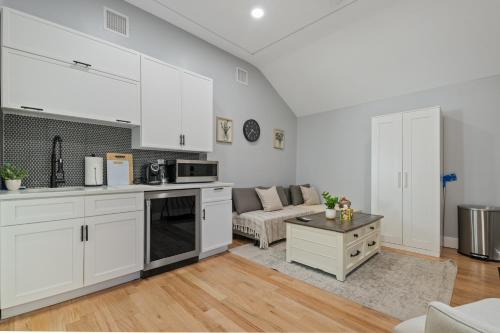 a kitchen and living room with white cabinets and a couch at Lunavista Cozy Studio in Hempstead