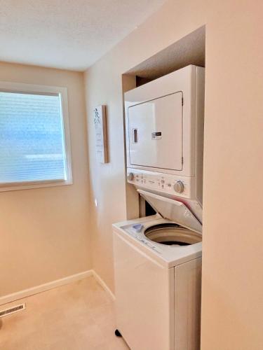 a washer and dryer in a room with a window at Cozy Main Level Torch Lake Stay with Private Entry & Fire Pit in Rapid City