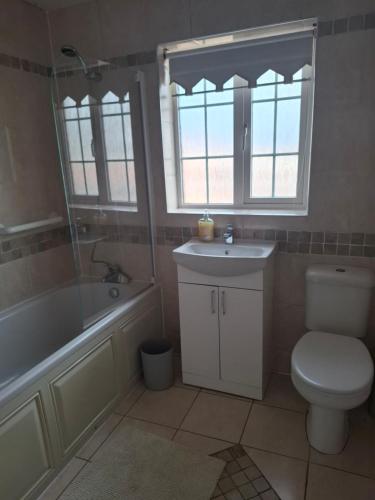 a bathroom with a toilet and a tub and a sink at Arthur house in Whitehouse Lower