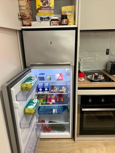 a refrigerator with its door open with food inside at Bellavista Qerret Apartments in Golem