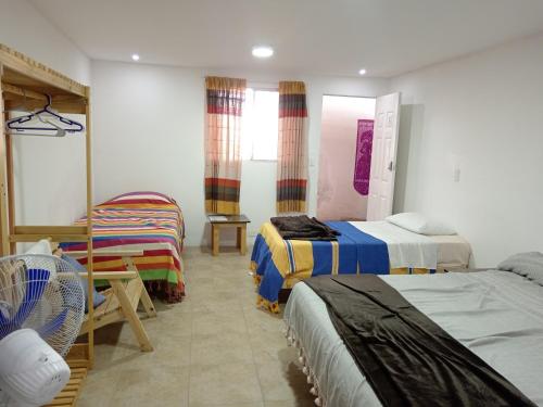 a room with two beds and a chair in it at Iguana Coliving in Oaxaca City