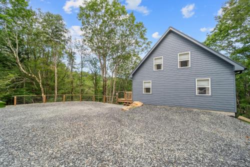 a house with a dog laying on a gravel driveway at Pine Ridge Retreat in Beech Mountain