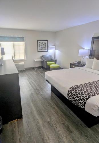 a hotel room with a bed and a desk and a chair at La Quinta by Wyndham Prattville in Prattville