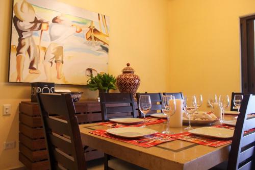 a dining room with a table with wine glasses at Casa Bul-Kay's in Chicxulub